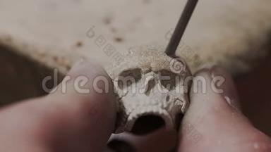 金匠制造不寻常的珠宝戒指形状的头骨。 他在金属上钻洞。 专业的珠宝工匠。 细节